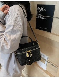 Chic black woven PU bucket bag for women featuring gold hardware and a chain strap