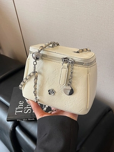 Petit sac boîte en cuir crème avec breloque camélia argentée et bandoulière chaîne