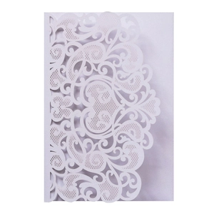 Detail of laser-cut wedding invitation featuring intricate floral patterns in lavender