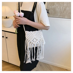 Detail shot of the white woven cotton rope bag with long tassels and bohemian pattern