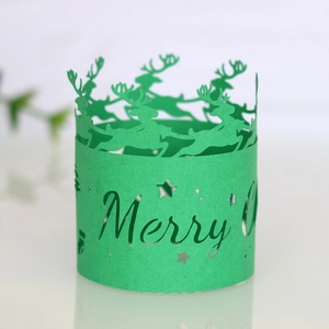 Detail of green laser-cut Christmas paper napkin ring with reindeer and Merry Christmas text