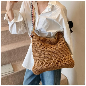 Détail du sac hobo en paille tressée avec bandoulière ethnique et boucle en bois