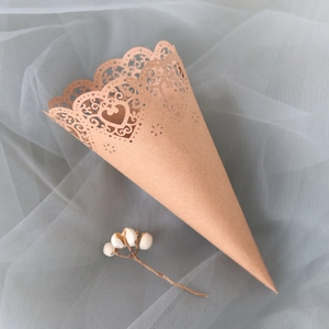 Detailed close-up of laser-cut heart lace edge on kraft paper wedding confetti cone