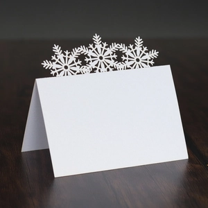 Laser cut snowflake place cards in pearl white for elegant Christmas table settings