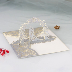 Detailed laser-cut wedding invitation featuring 3D pop-up couple and silver glitter floral art