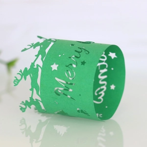 Close-up of laser-cut green Christmas napkin rings with reindeer and star patterns