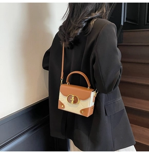 Detailed view of bicolor crossbody bag with bear embossing and gold twist lock