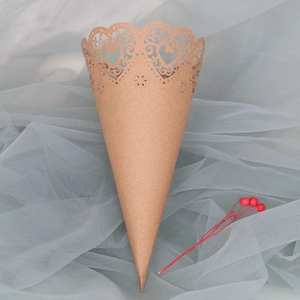 Detailed laser-cut heart lace pattern on a rustic kraft paper wedding confetti cone