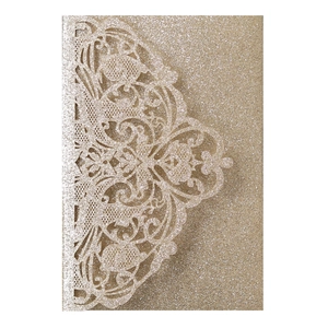 Close-up of champagne gold glitter wedding invitation with laser cut lace texture