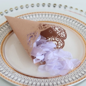 Laser-cut kraft paper wedding confetti cone with lavender petals on elegant vintage plate