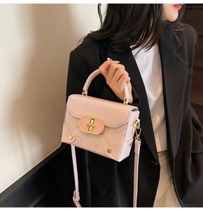 Detail of pink leather handbag featuring cartoon bear prints and gold oval lock buckle