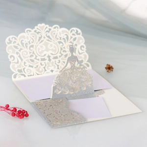 Detail of 3D laser-cut wedding invitation featuring a glittery bride silhouette in ivory