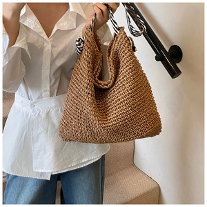 Détail macro du sac cabas en paille tressée avec des anses en satin à imprimé zèbre chic