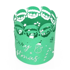Detail of green laser-cut Christmas paper cup wrapper with Santa and snowman motifs