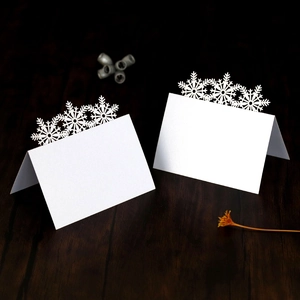 Laser cut snowflake place cards in pearl white for winter weddings and holiday tables