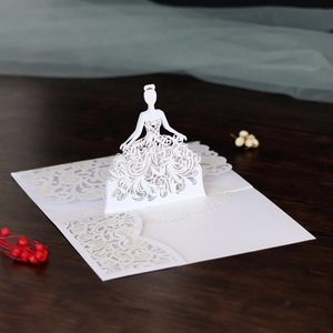 Detail of laser-cut 3D bridal invitation card with intricate lace dress pattern