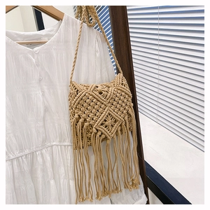 Macro view of bohemian hand-woven cotton rope bag with long fringe and geometric patterns
