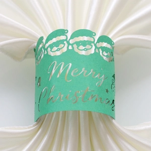 Détail d'un rond de serviette vert menthe découpé au laser avec motif Père Noël festif