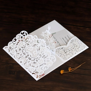 Detail of 3D laser-cut lace wedding invitation with pop-up bride on wooden background
