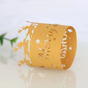 Macro view of gold laser-cut paper napkin ring with reindeer and Merry Christmas text