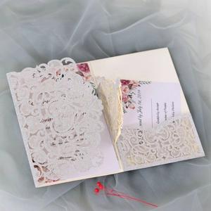 Macro detail of laser-cut silver glitter wedding invitation with floral RSVP card