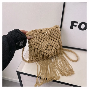 Detail of handmade macrame crossbody bag with woven cotton fringe and boho strap
