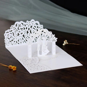 Dettaglio di biglietto di nozze 3D con motivi a rose e sagoma di coppia tagliati al laser