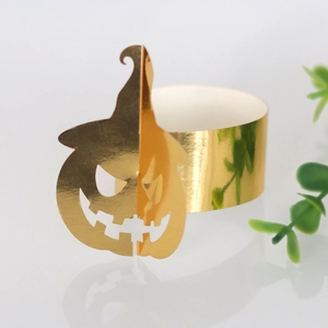 Close-up of golden hollow pumpkin napkin ring with metallic luster for Halloween table decor