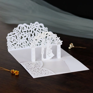 Dettaglio dell'invito di nozze 3D tagliato al laser con rose e silhouette di sposi