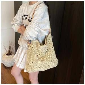 Détail du sac cabas en paille tressée avec bandoulière colorée au style bohème chic