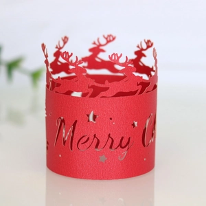 Close-up of red laser-cut Merry Christmas cupcake wrappers with reindeer and star patterns