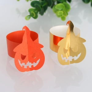 Detail of orange and gold pumpkin napkin rings with jack-o'-lantern cutouts for Halloween