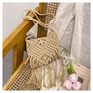 Detail of handmade cotton rope woven crossbody bag with fringe hanging on vintage chair