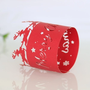 Macro shot of red laser-cut paper Christmas napkin ring with reindeer and star patterns