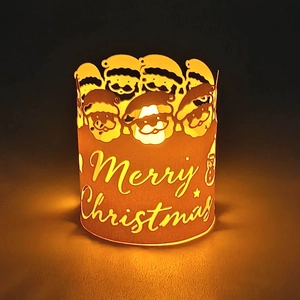 Detail of warm LED glow through Santa Claus pattern on red metallic Christmas lantern