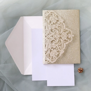 Detail of laser-cut glitter gold mandala invitation with white envelopes and inner cards
