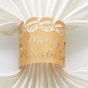 Détail d'un rond de serviette doré avec motif de Père Noël découpé au laser