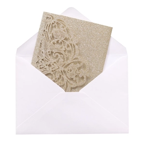 Detail of laser-cut gold glitter wedding invitation card with floral patterns and white envelope