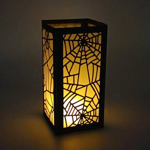 Halloween rectangular lantern with laser-cut spider web design and warm yellow LED light