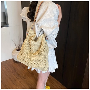 Vue détaillée du sac cabas en paille avec bandoulière large brodée au style ethnique
