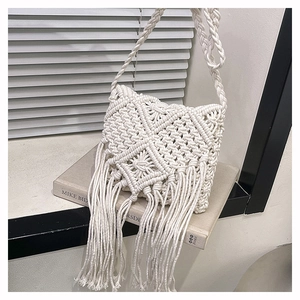 Detailed close-up of handmade cream macramé weaving and long fringes on a bohemian bag