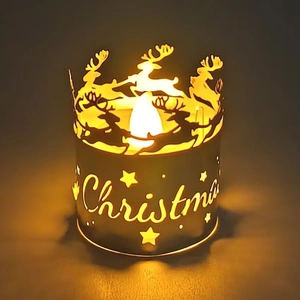 Gros plan d'un photophore de Noël en métal découpé au laser avec renne et lumière LED chaude