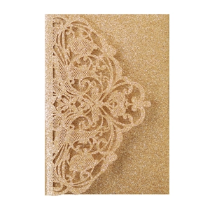Detail of laser-cut gold glitter wedding invitation card with intricate lace patterns