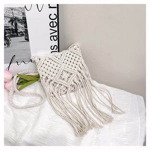 Detailed close-up of handmade cream cotton woven crossbody bag with long fringes
