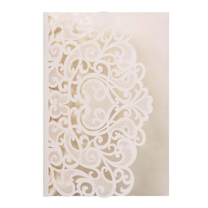 Detail of laser-cut wedding invitation with intricate lace patterns and pearl white finish