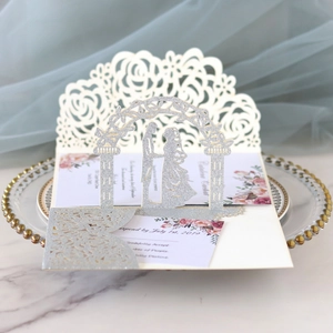 Detail of silver glitter wedding invitation with laser cut arch on elegant glass plate
