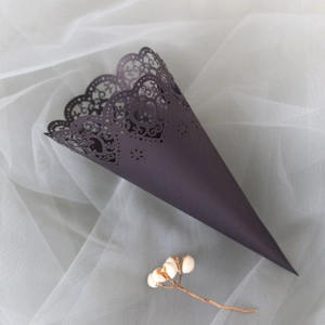 Macro detail of laser-cut heart pattern on dark purple cone for wedding petals