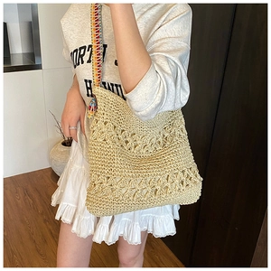 Détail d'un sac cabas bohème en paille tressée beige avec bandoulières colorées