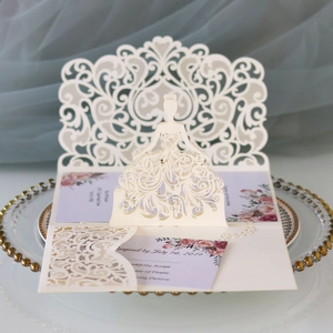 Close-up of laser-cut 3D bridal invitation with intricate lace patterns and cream cardstock