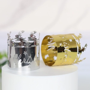 Close-up of polished Christmas napkin rings with reindeer and Merry Christmas cutouts